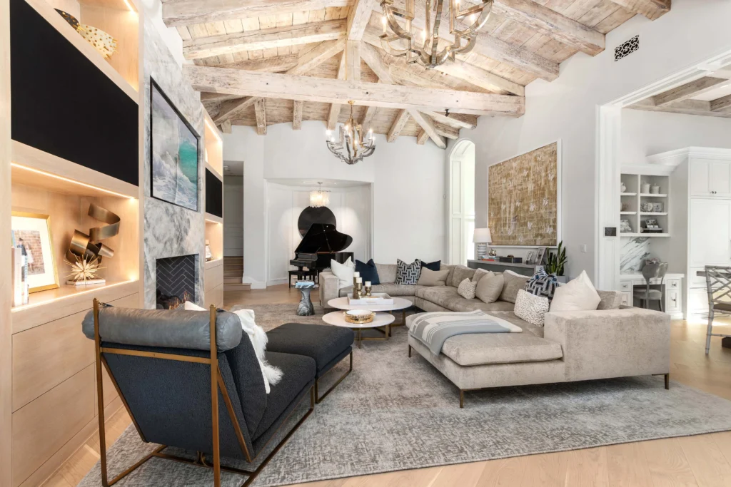 A stylish living room featuring a modern design with a TV mounted on the wall. The clean lines and neutral color palette create a serene environment perfect for both relaxation and entertainment.